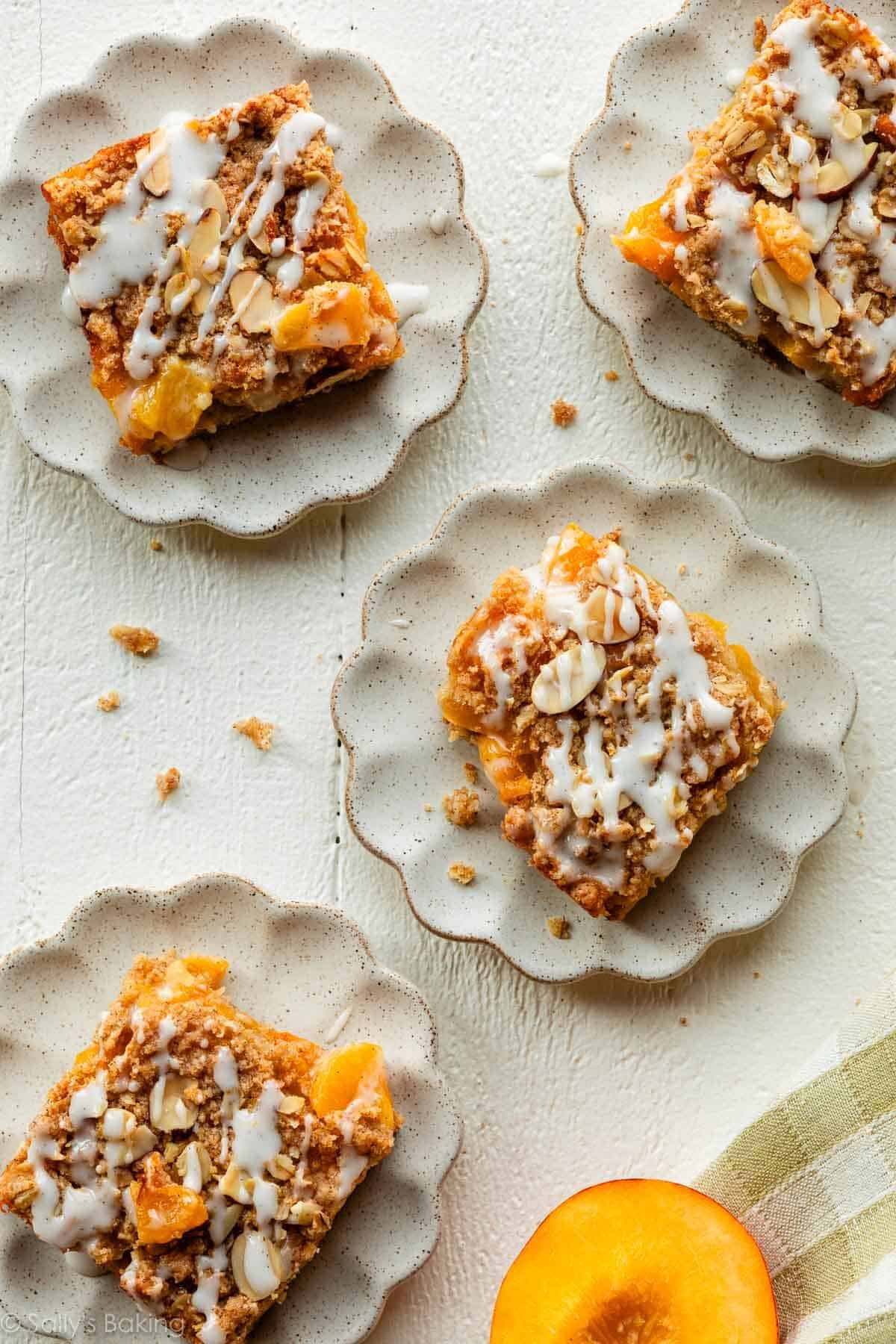 peach pie crumb bars on scalloped plates.