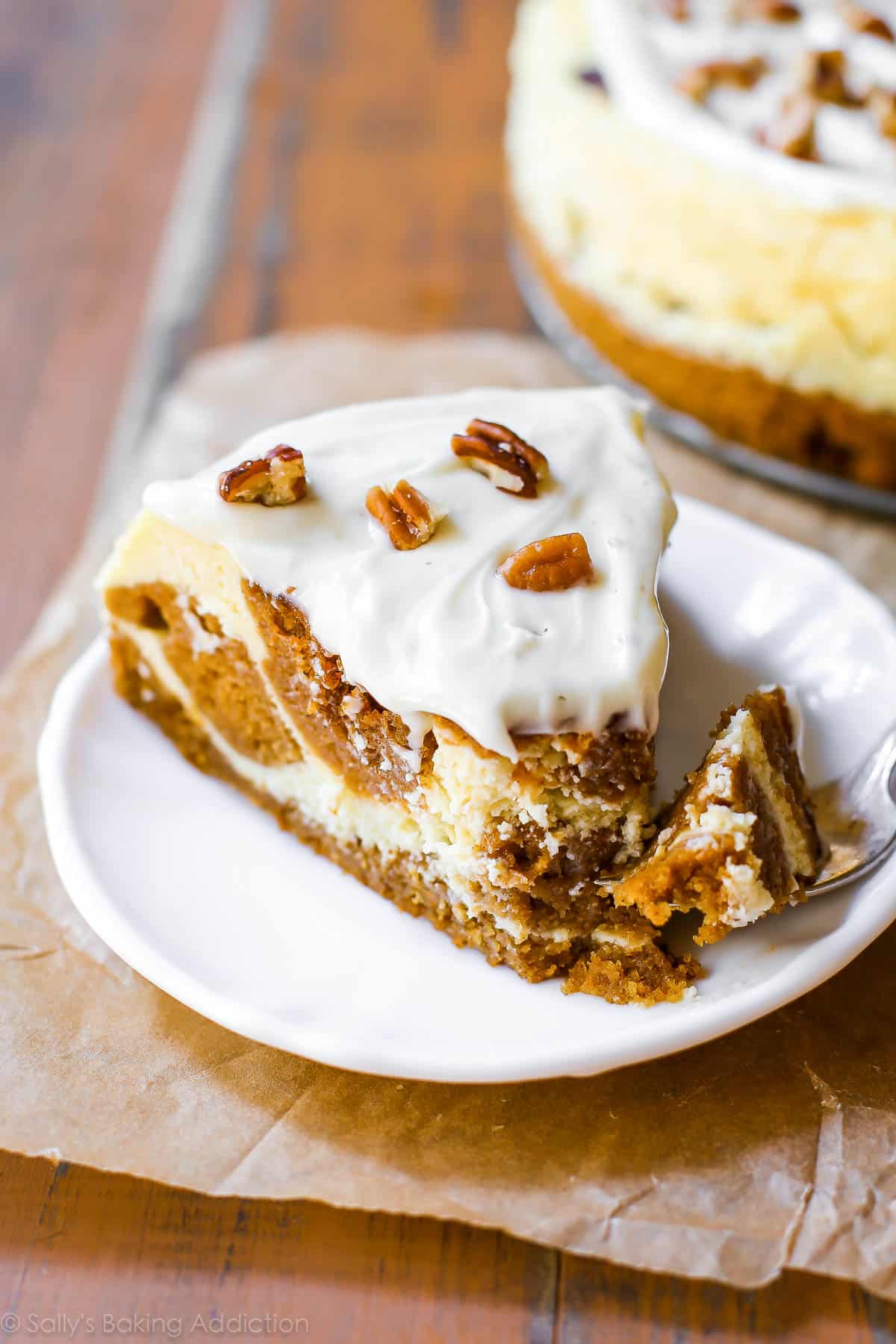 slice of pumpkin cake cheesecake on a white plate