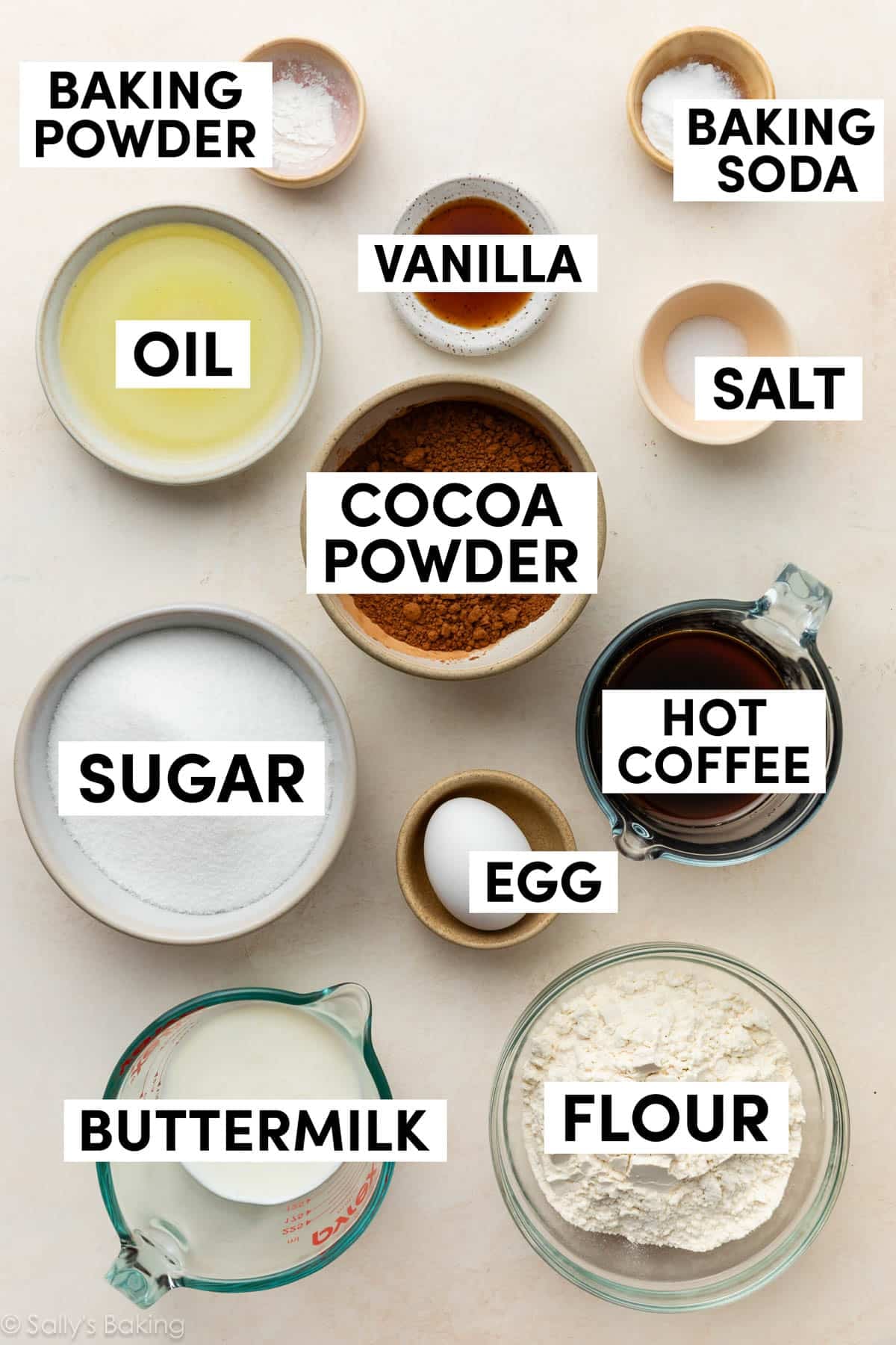 ingredients in bowls including oil, cocoa powder, sugar, flour, and baking soda.
