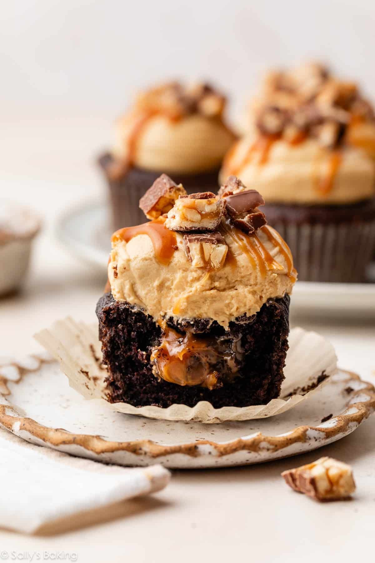 snickers cupcake with caramel filling cut in half.