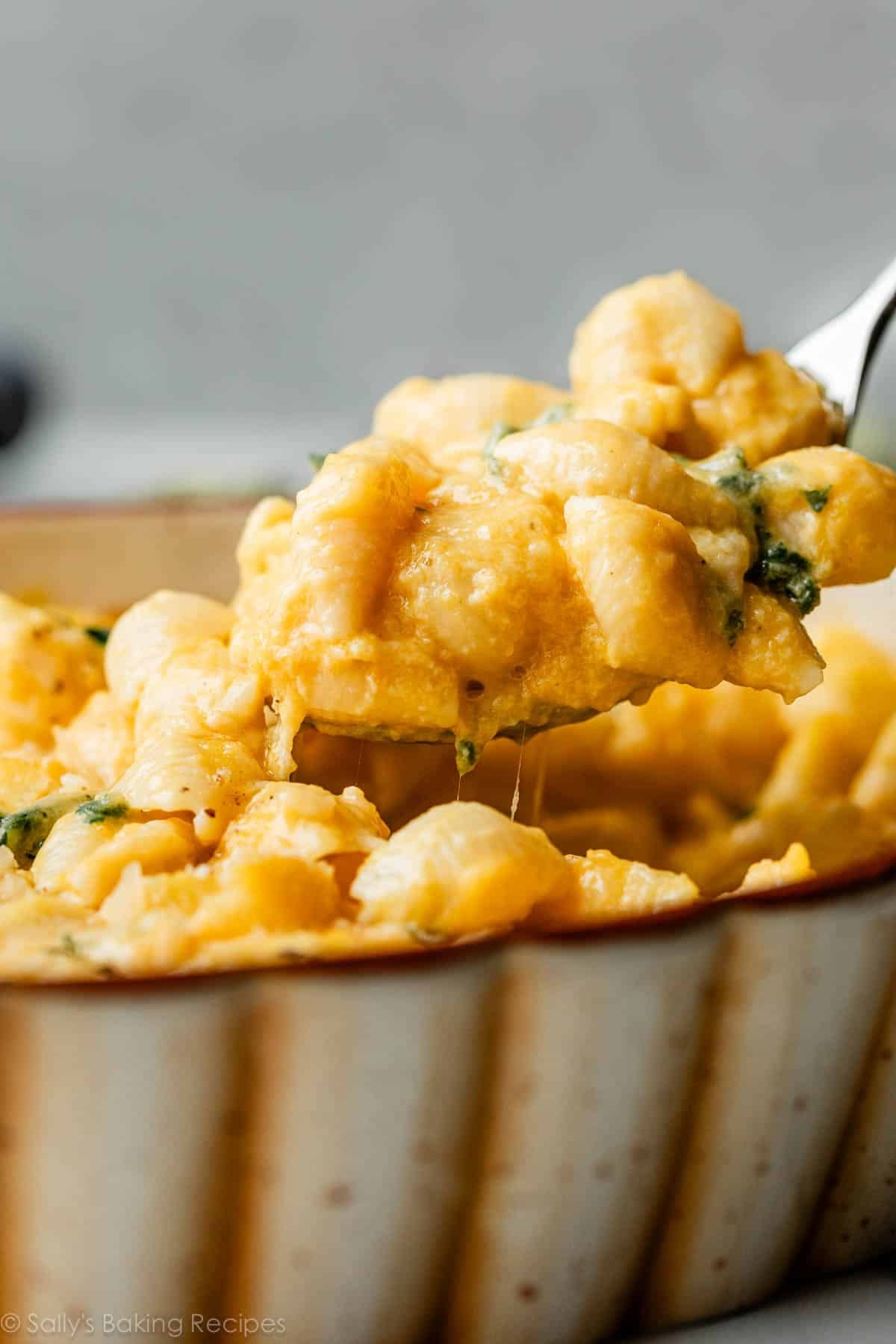 spoonful of butternut squash mac and cheese coming out of the pan.