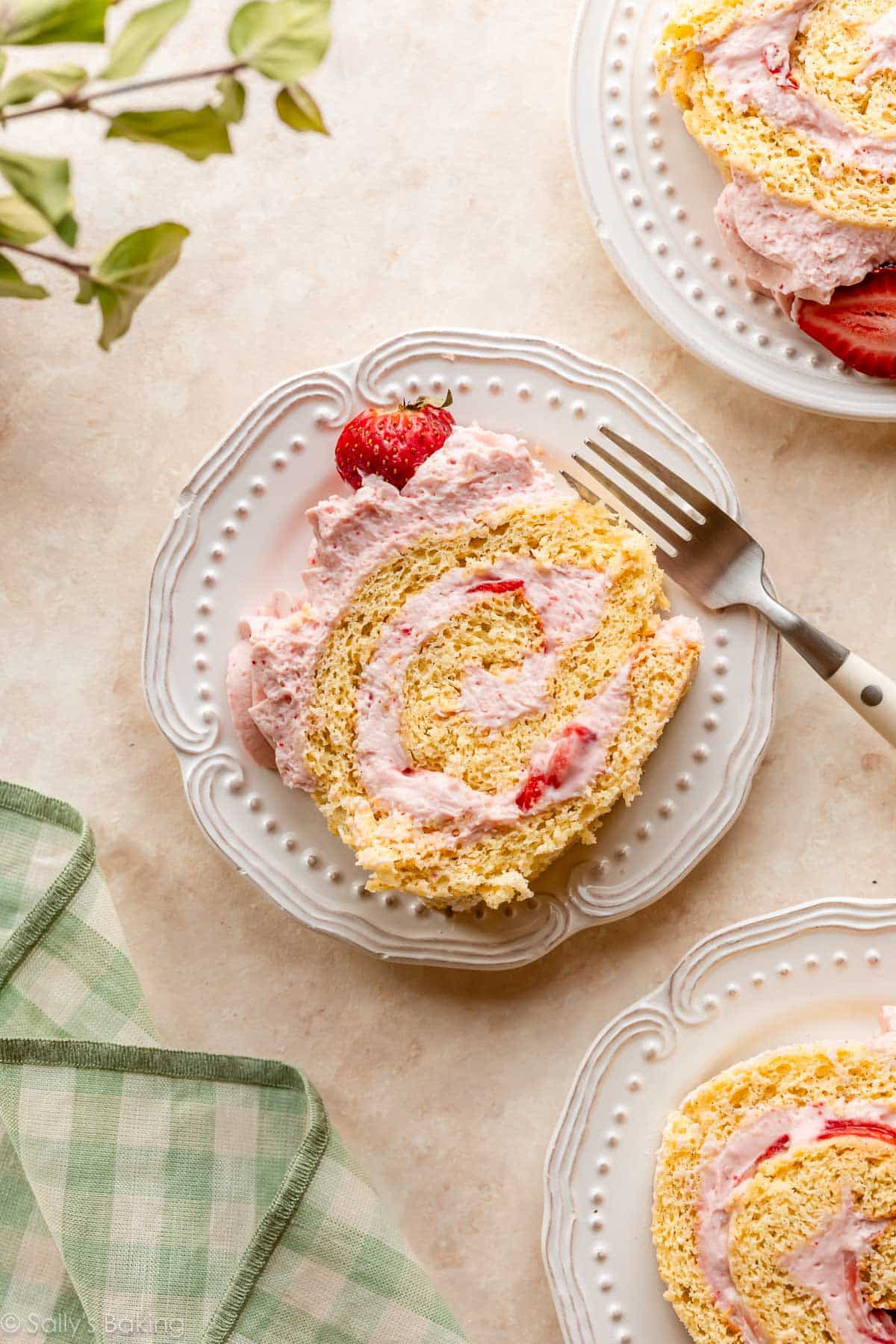 strawberry cake roll slices on white plates.