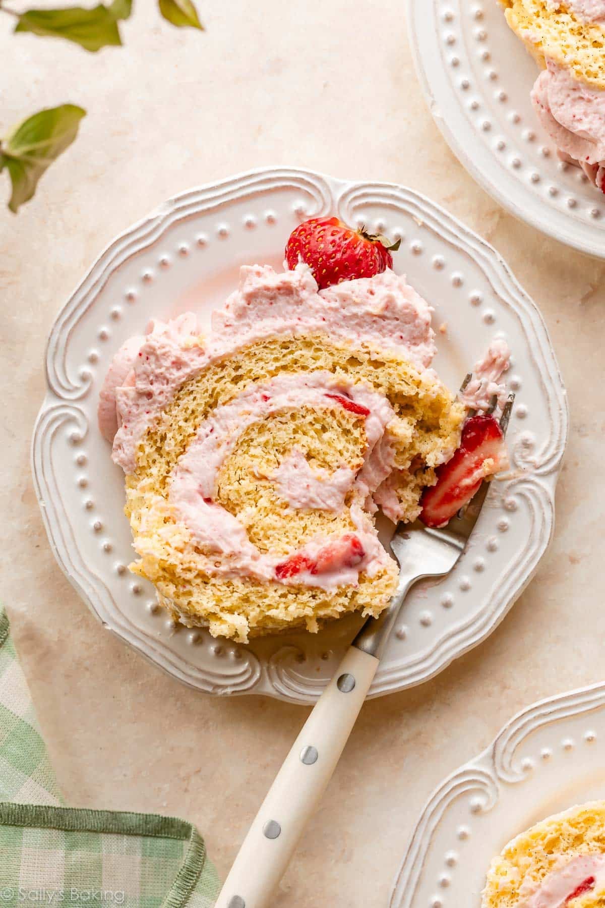 strawberry cake roll slices on white plates.