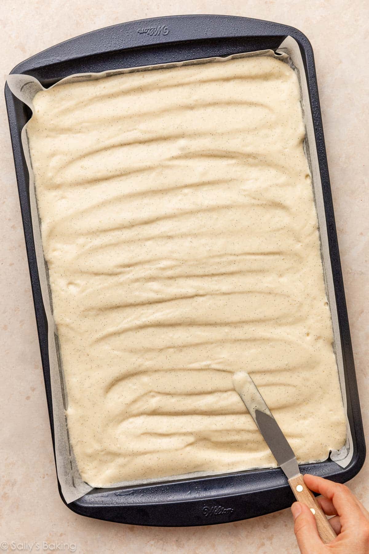 spreading cake batter into sheet pan.
