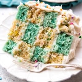 slice of checkerboard cake on a white plate with a fork