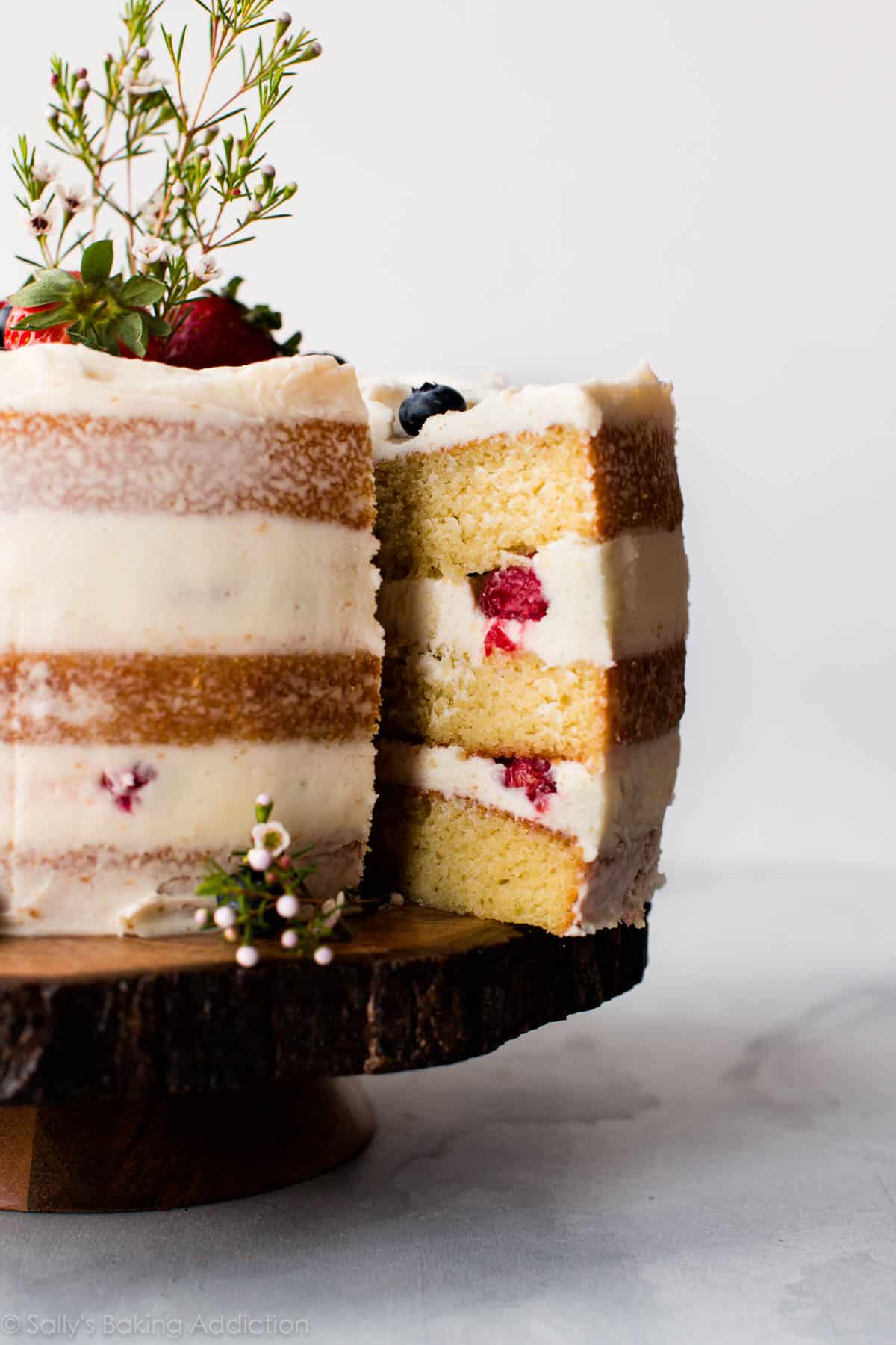 Vanilla naked cake on a wood slice cake stand