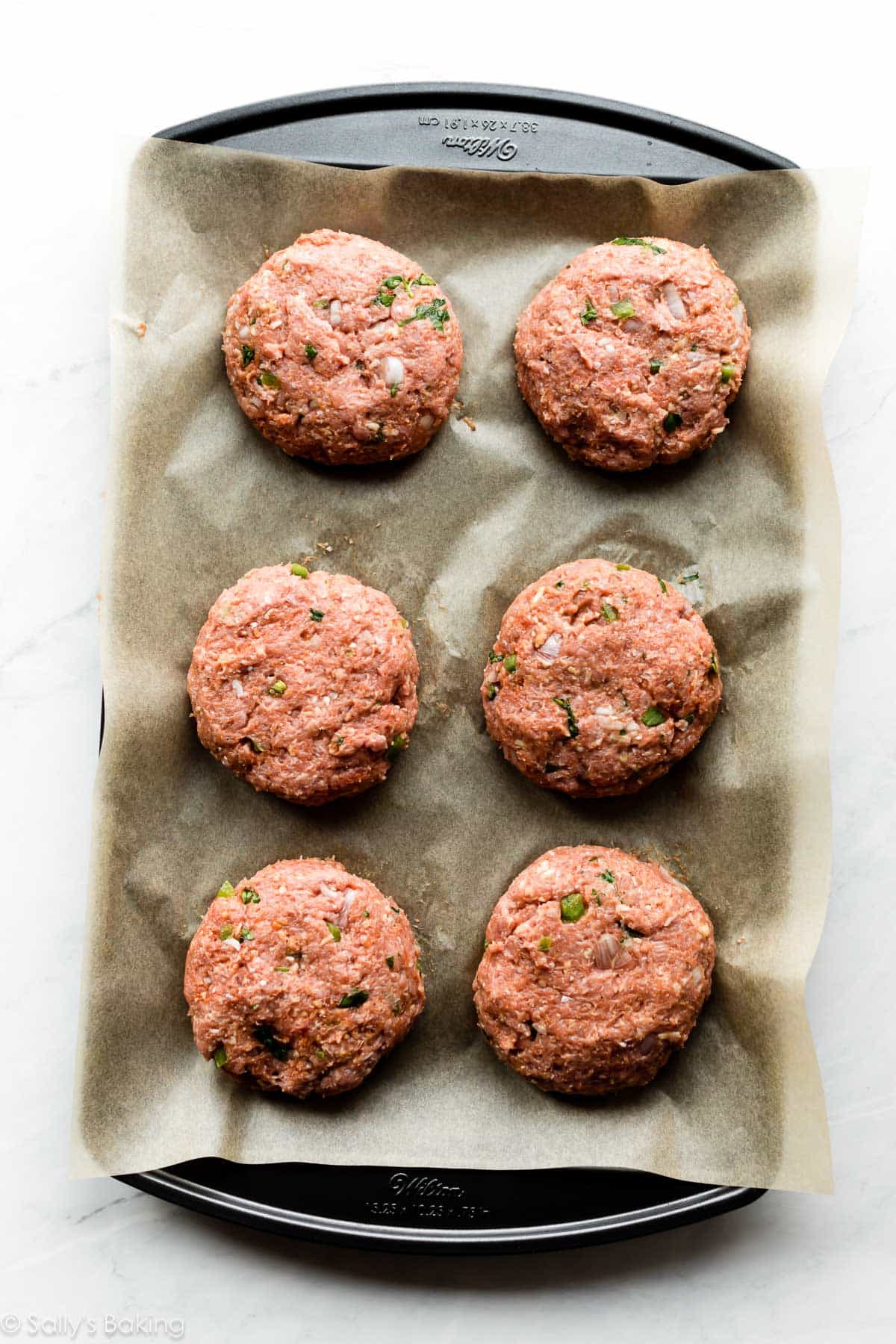 raw turkey burgers on sheet tray.