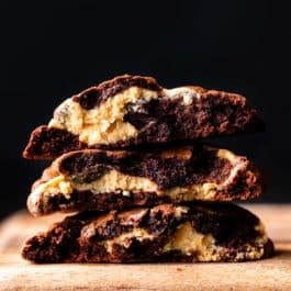 stack of peanut butter filled brownie cookies broken in half