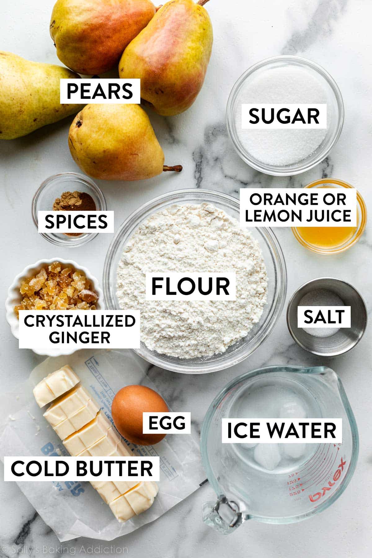 ingredients on counter including flour, pears, sugar, salt, ice water, cold butter, ginger, and more.