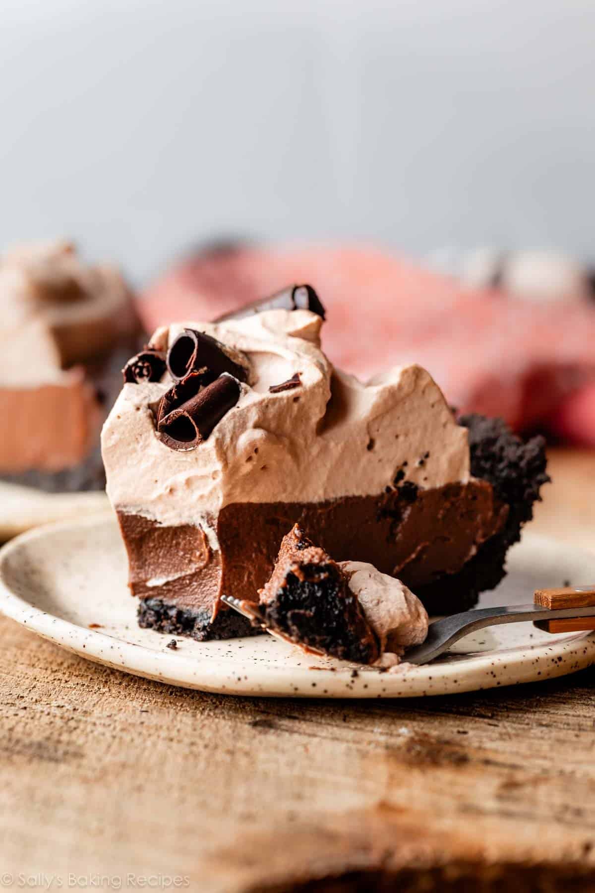 slice of mocha chocolate pudding pie on Oreo cookie crust with chocolate curls on top.