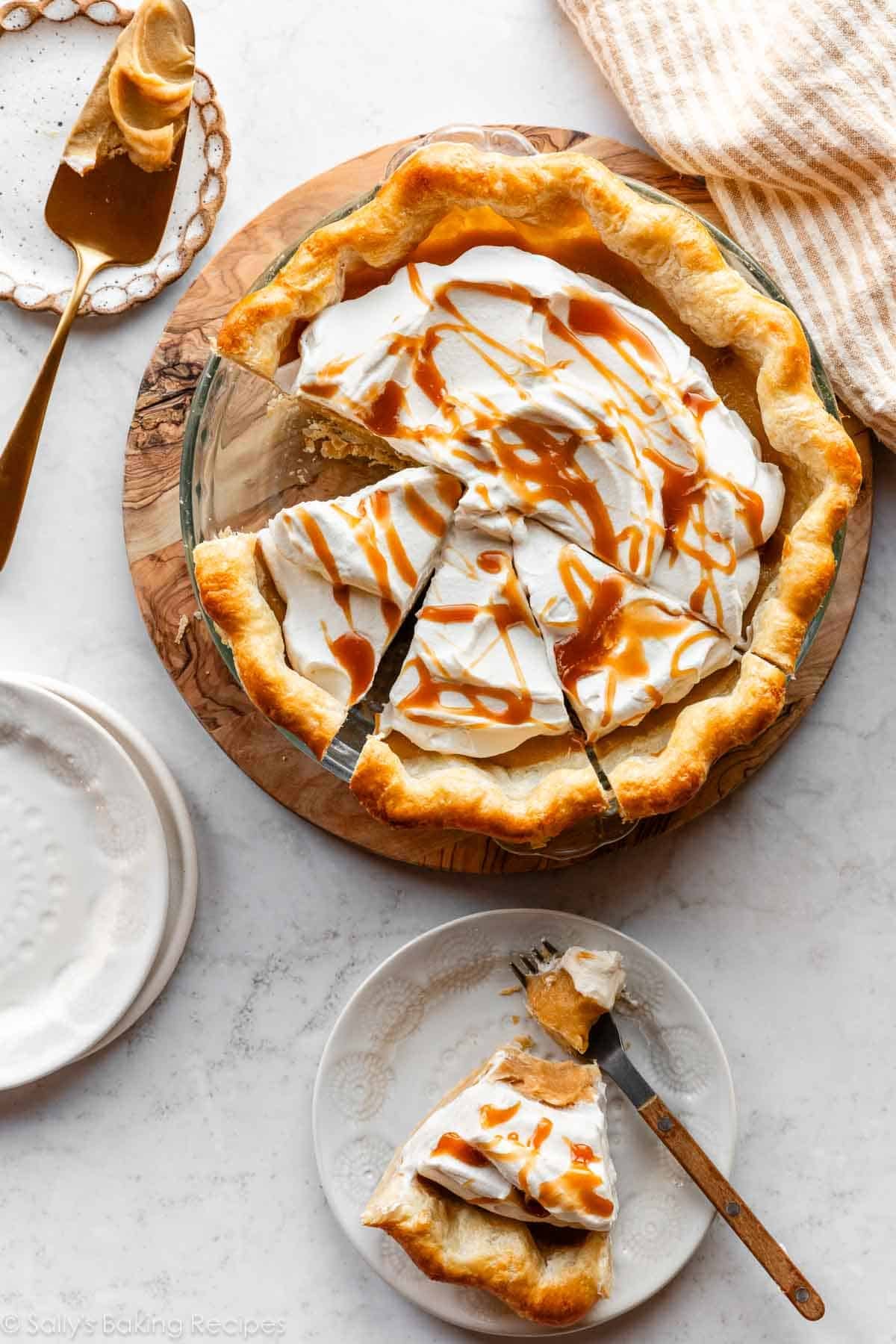 overhead photo of sliced butterscotch pie with slice removed on white plate.