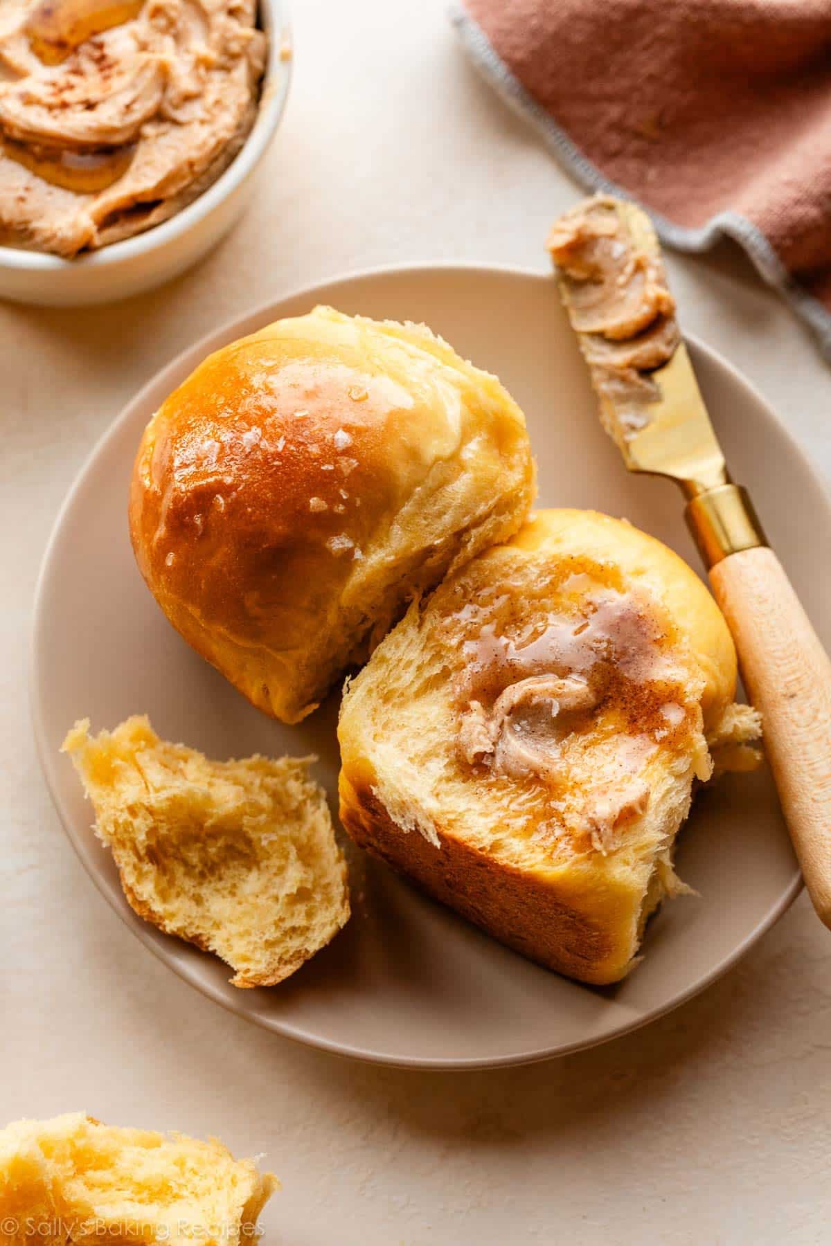 potato rolls on beige plate with cinnamon butter on top.
