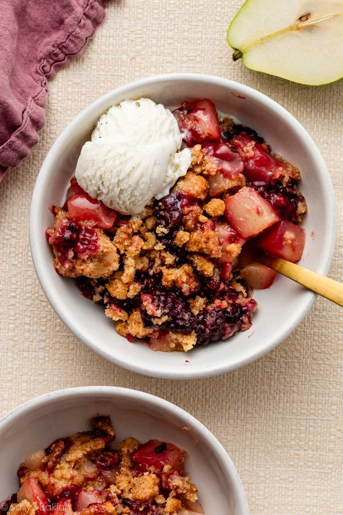 pear berry crumble in bowl with ice cream.