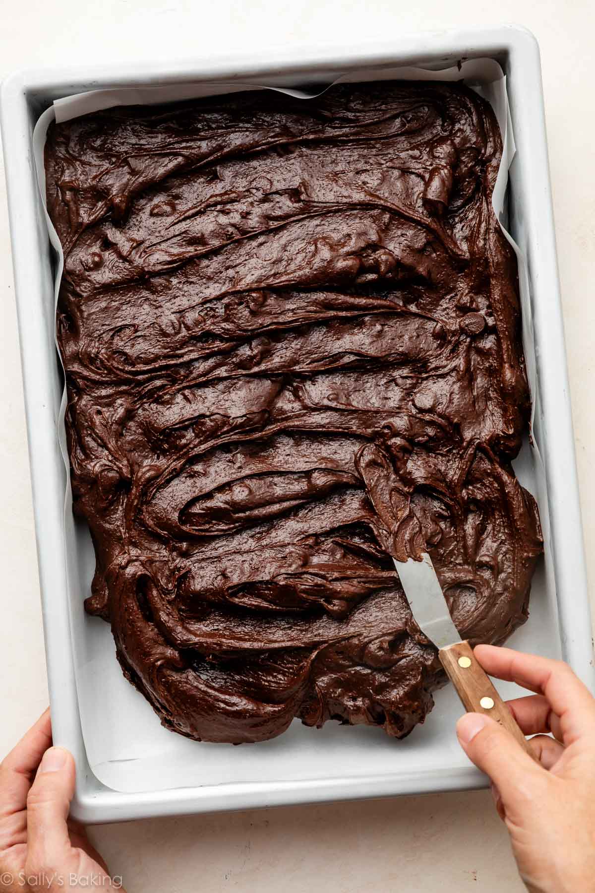 spreading batter into metal baking pan.