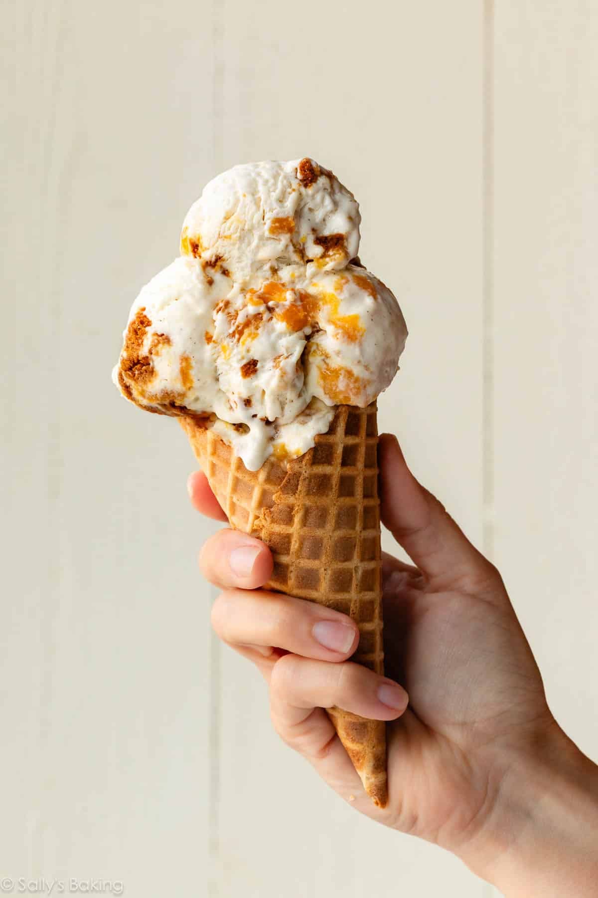 peach cheesecake ice cream in a waffle cone.