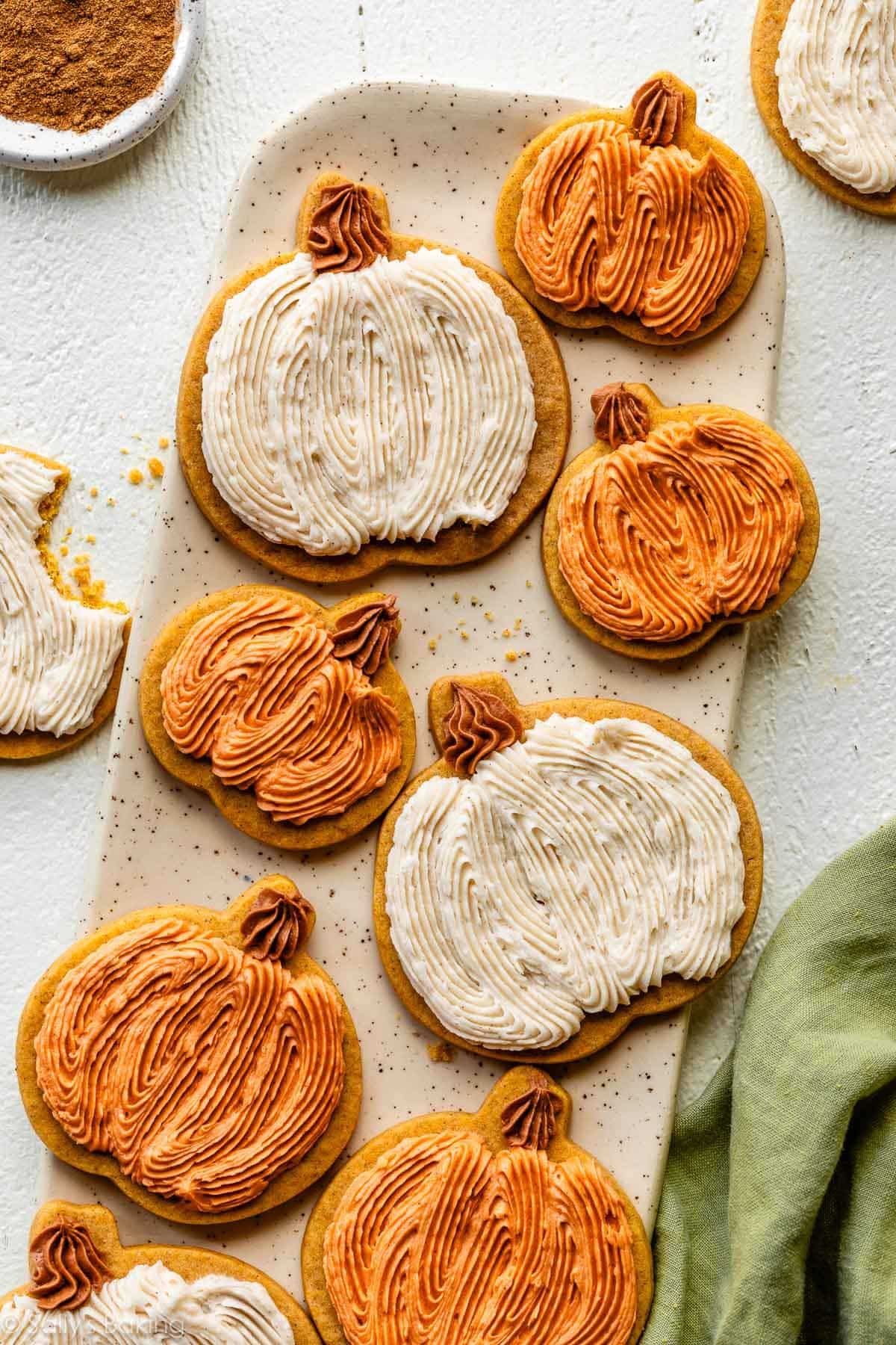 Frosted pumpkin sugar cookies on a platter.